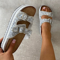 Embellished silver platform sandals with two square buckles and rhinestone straps.