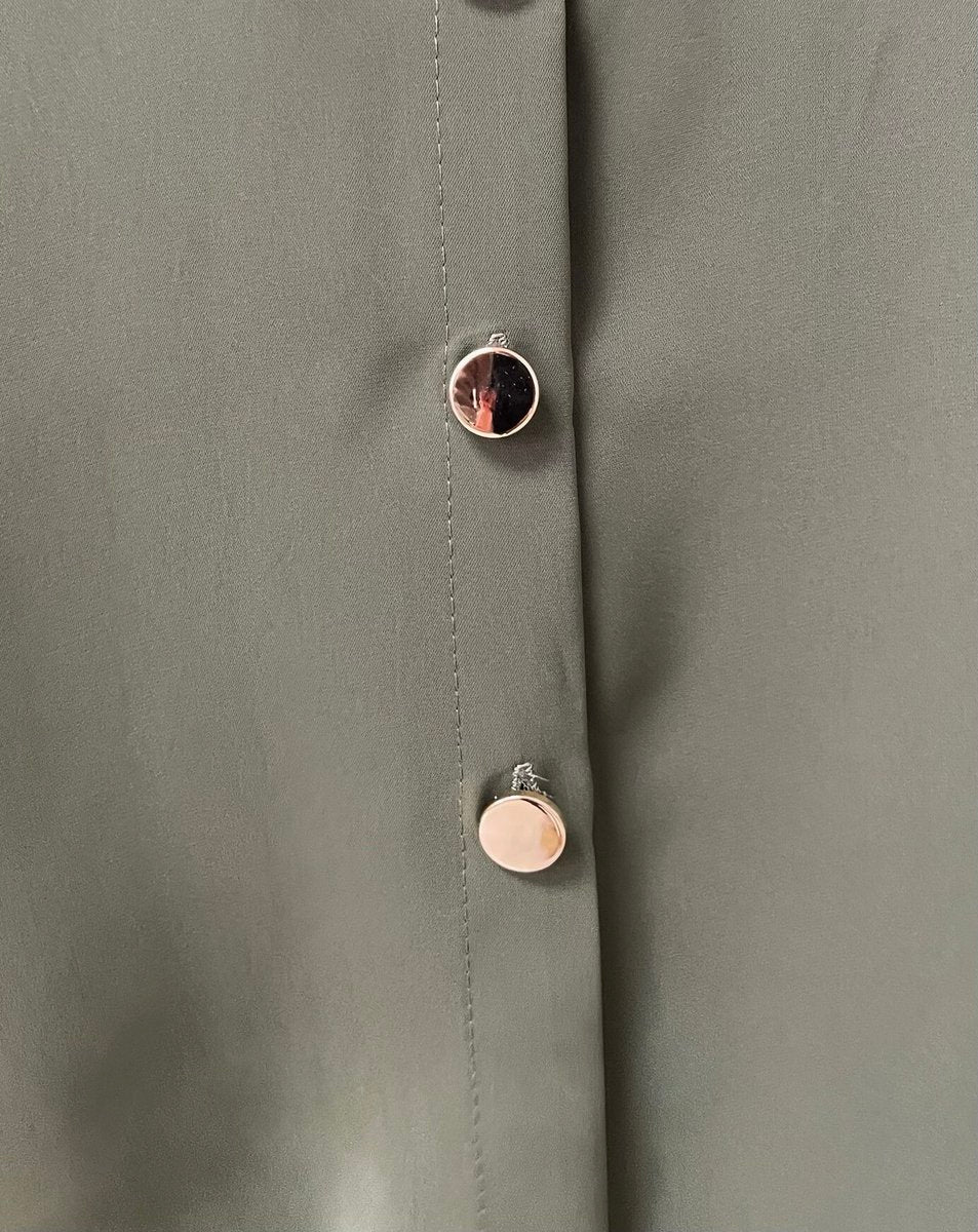 Oversized collared button-down top fabric detail with round metal buttons on the placket.