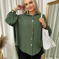 Oversized collared button-down top in dark green with gold buttons and loose long sleeves.