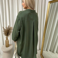 Oversized collared button-down top in dark green, back view with relaxed drape and buttons.