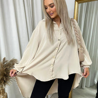 Beige oversized collared button-down top with long sleeves and button placket