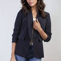 Dark navy open-front blazer jacket with ruched sleeves and front pockets, standing view