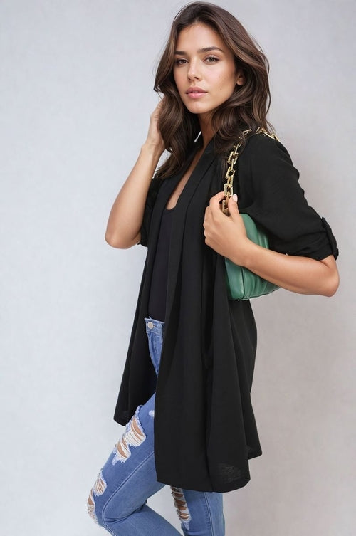 Black open-front cardigan with roll-up sleeves, loose drape over denim
