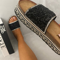 Black glitter platform slide sandals with wide strap and braided trim
