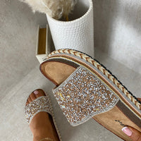 Gold-sparkle platform slide sandals with stone embellishments and braided trim