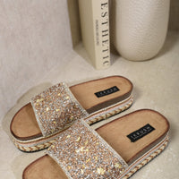 Gold glitter platform slide sandals with open toe, wide strap, and braided sole