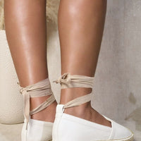 White espadrilles with ankle ties and woven jute toe caps, back view