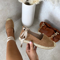 Tan suede espadrille with knotted ankle ties and woven toe cap, close-up
