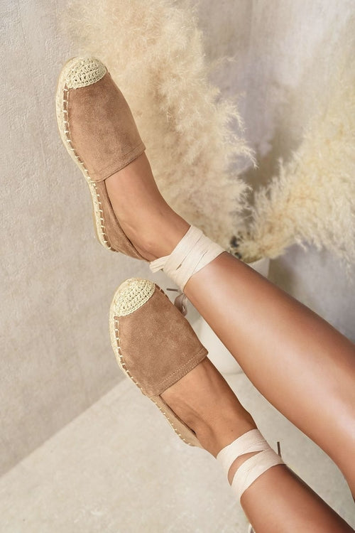 Beige espadrilles with ankle ties and woven jute toe cap, angled side view