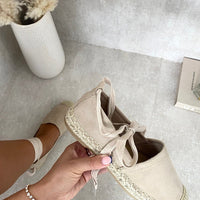 Beige espadrilles with ankle ties and woven toe cap, side view