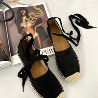 Black suede espadrilles with lace-up ankle ties and woven toe caps, pair view