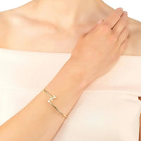 Gold-tone bangle bracelet on wrist with initial Z and crystals