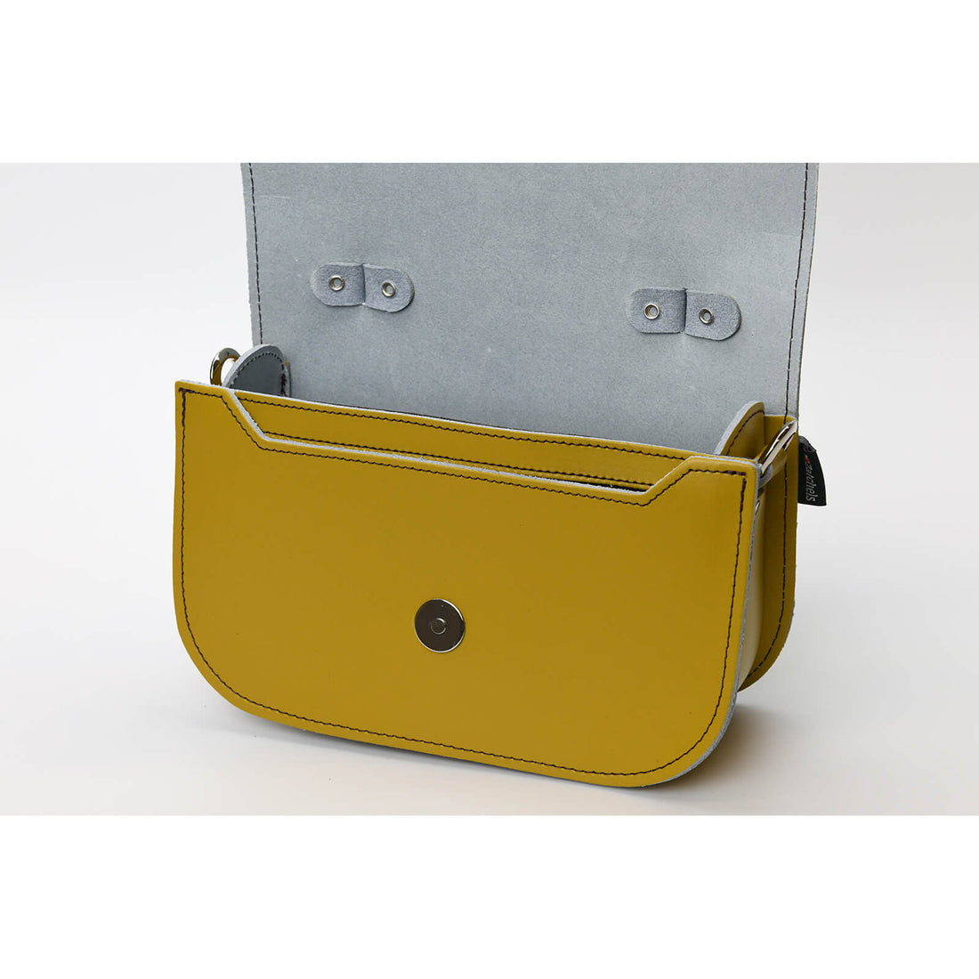 Yellow ochre leather crossbody bag with snap flap; gray fabric lining visible