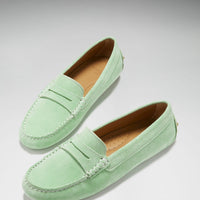 Pair of green suede penny driving loafers with tan insoles and stitched apron toes.