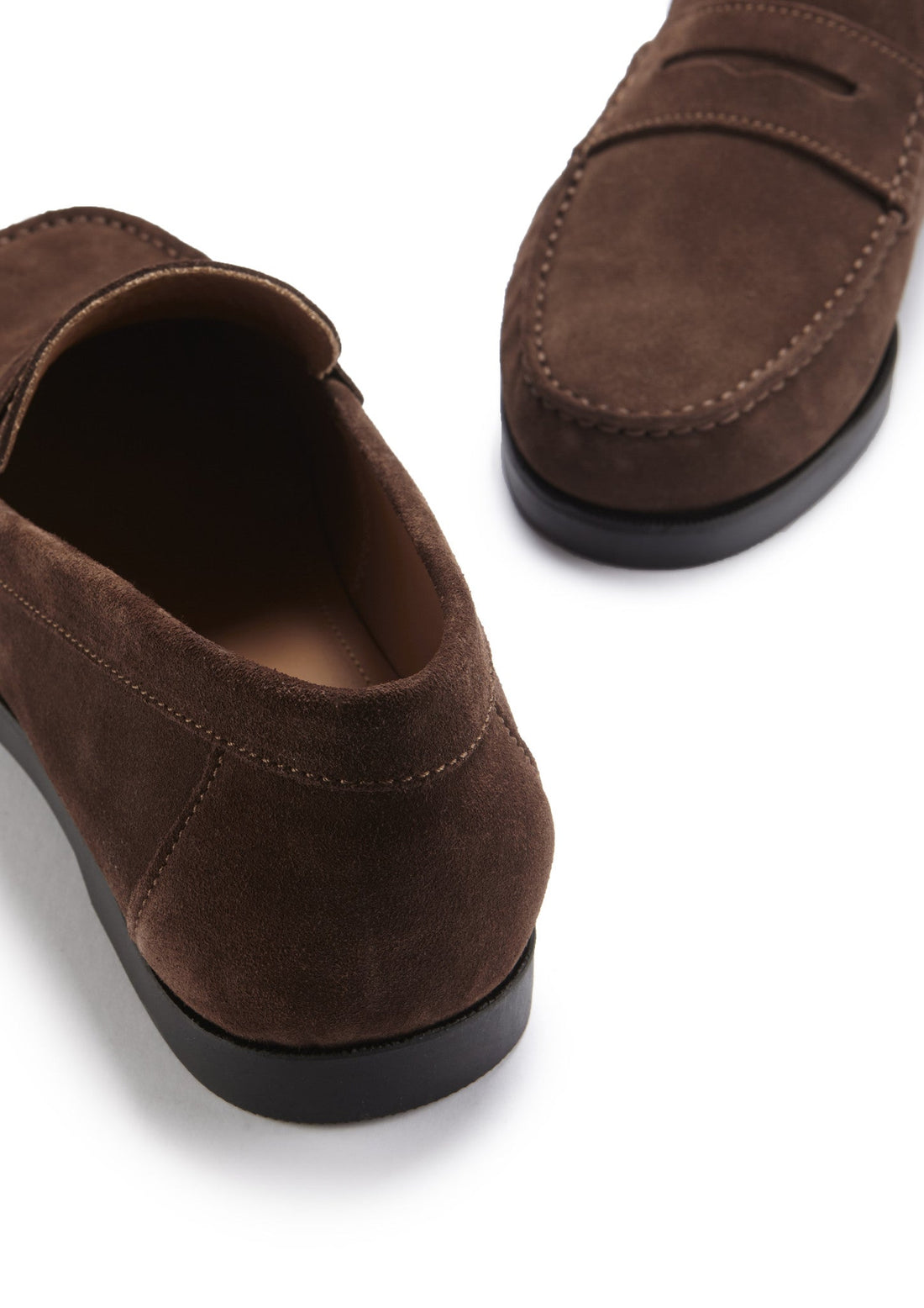 Brown suede loafer close-up showing the heel and stitched toe details
