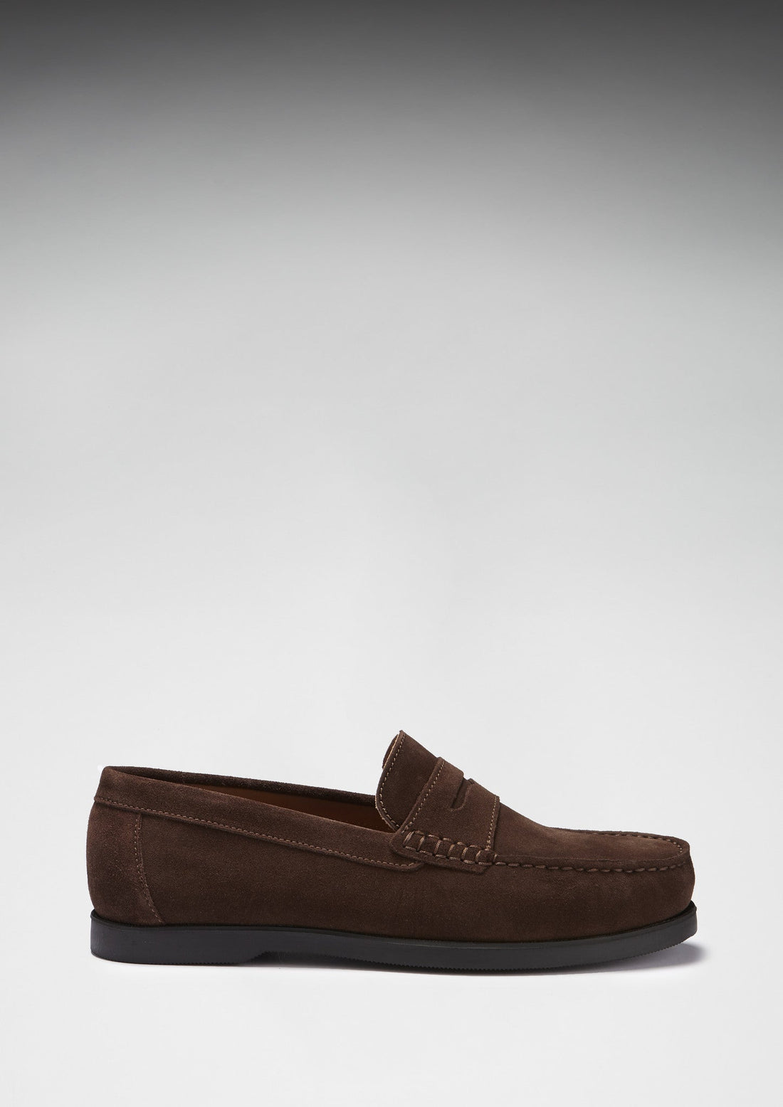 Brown suede loafer in side profile with a penny strap and black sole