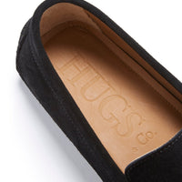 Black suede loafer close-up showing the tan leather insole embossed with Hugs & Co.