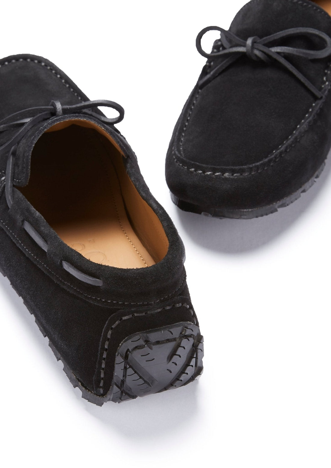 Pair of black suede driving loafers showing laces and textured heel grips