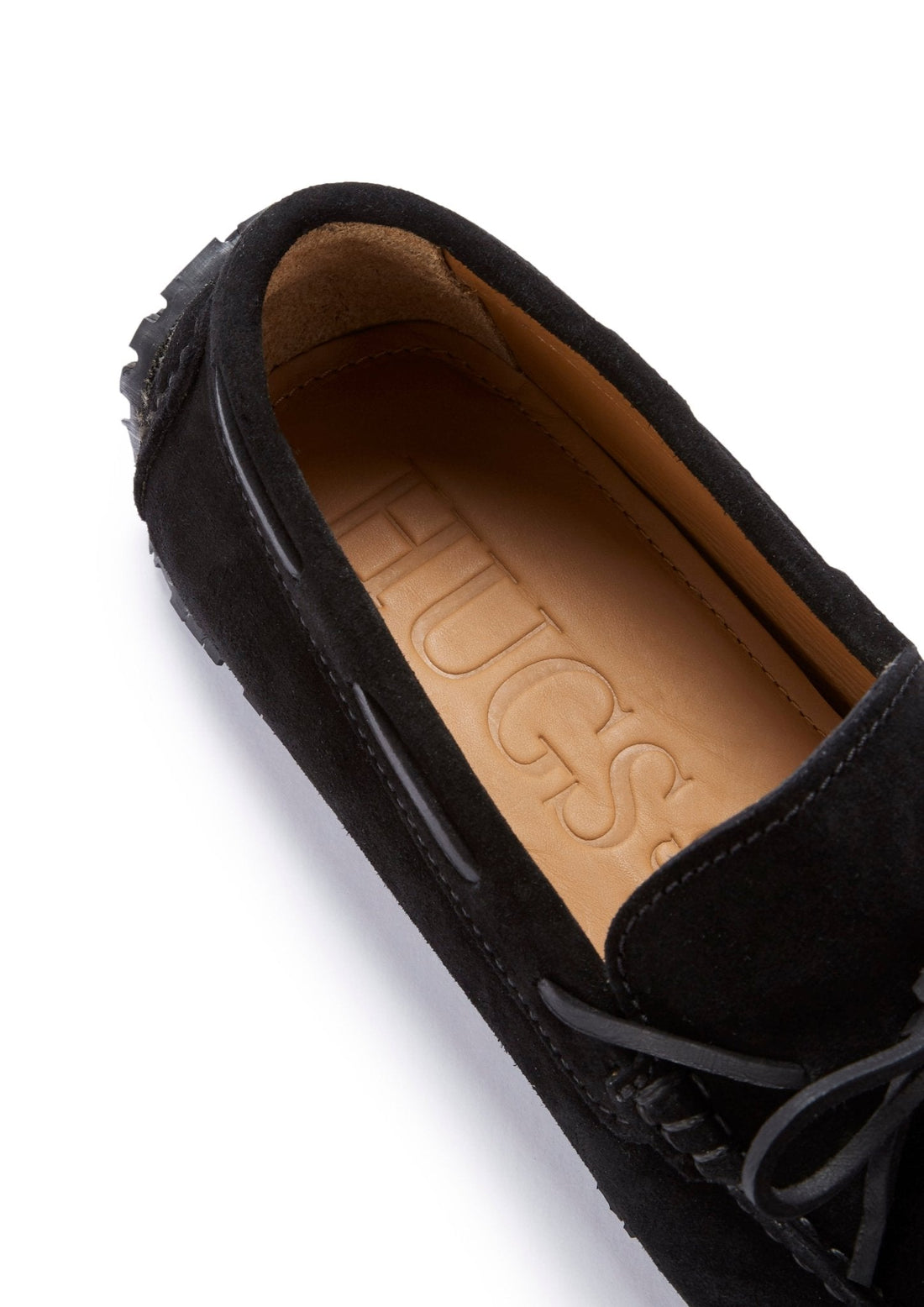 Black suede loafer showing tan leather insole and lace detail