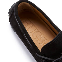 Black suede loafer showing tan leather insole and lace detail
