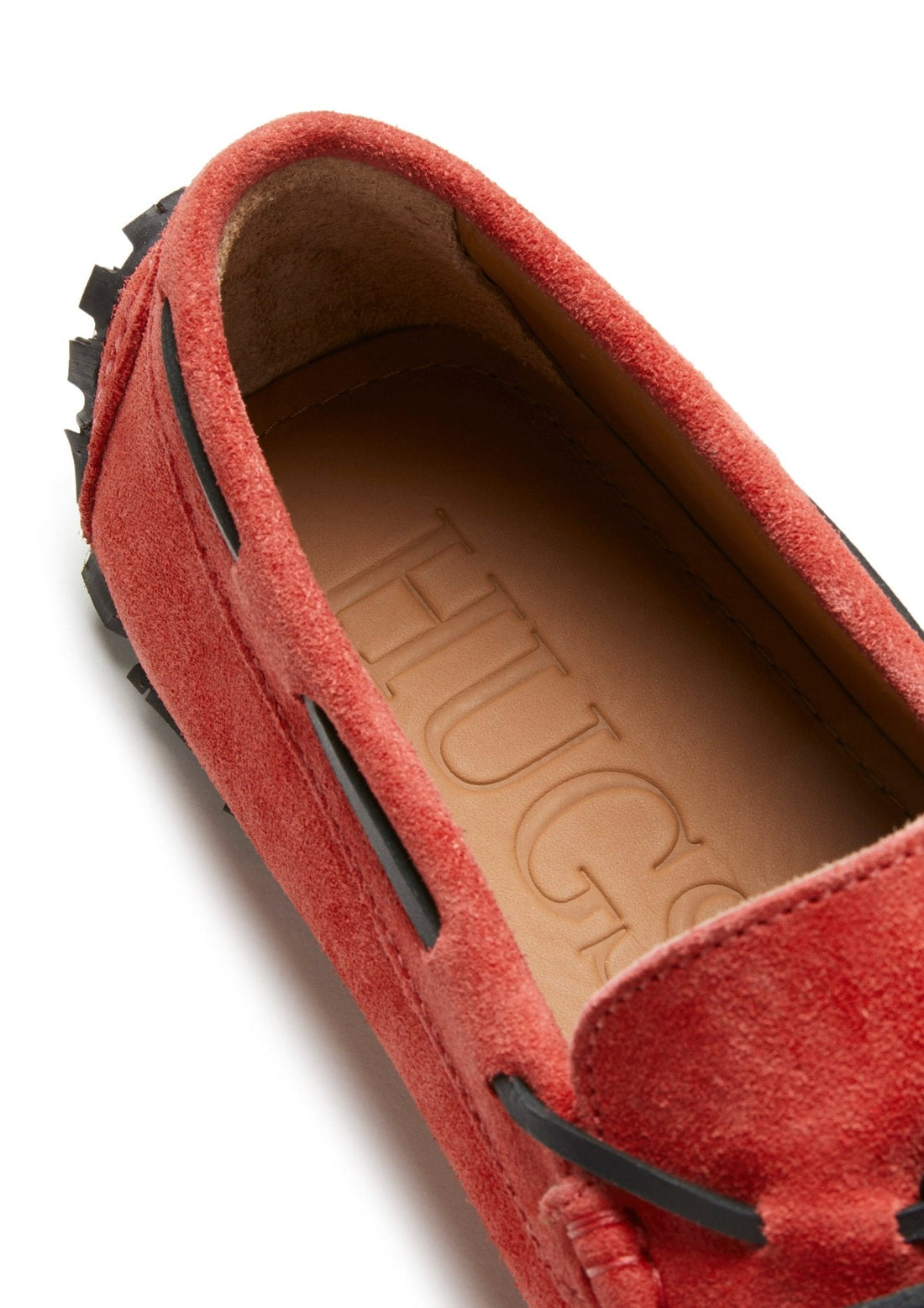 Red suede loafer showing the tan insole and black side lacing