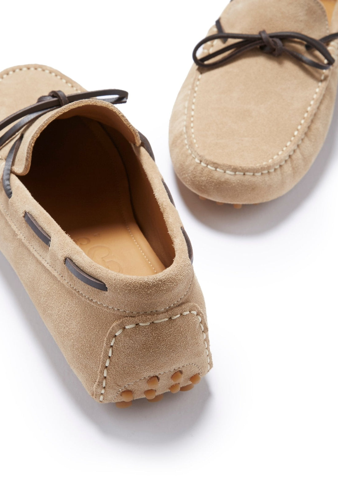 Taupe suede driving loafer showing the stitched heel, leather lining, and rounded sole pegs