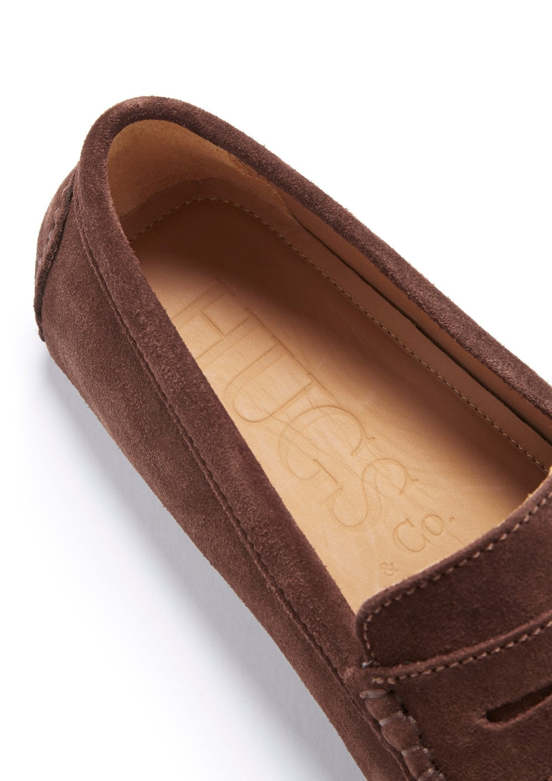 Close-up of brown suede loafer with tan insole and Hugs & Co. branding