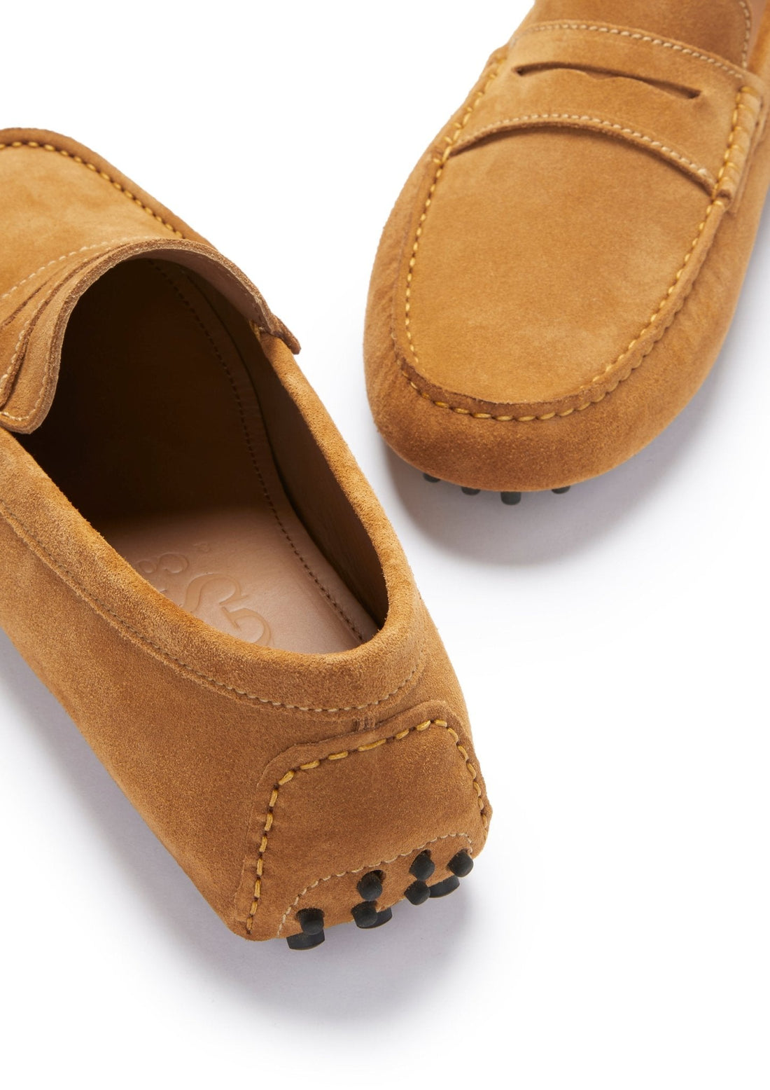 Tan suede driving loafer detail with stitched heel, apron toe, and rubber sole pods.