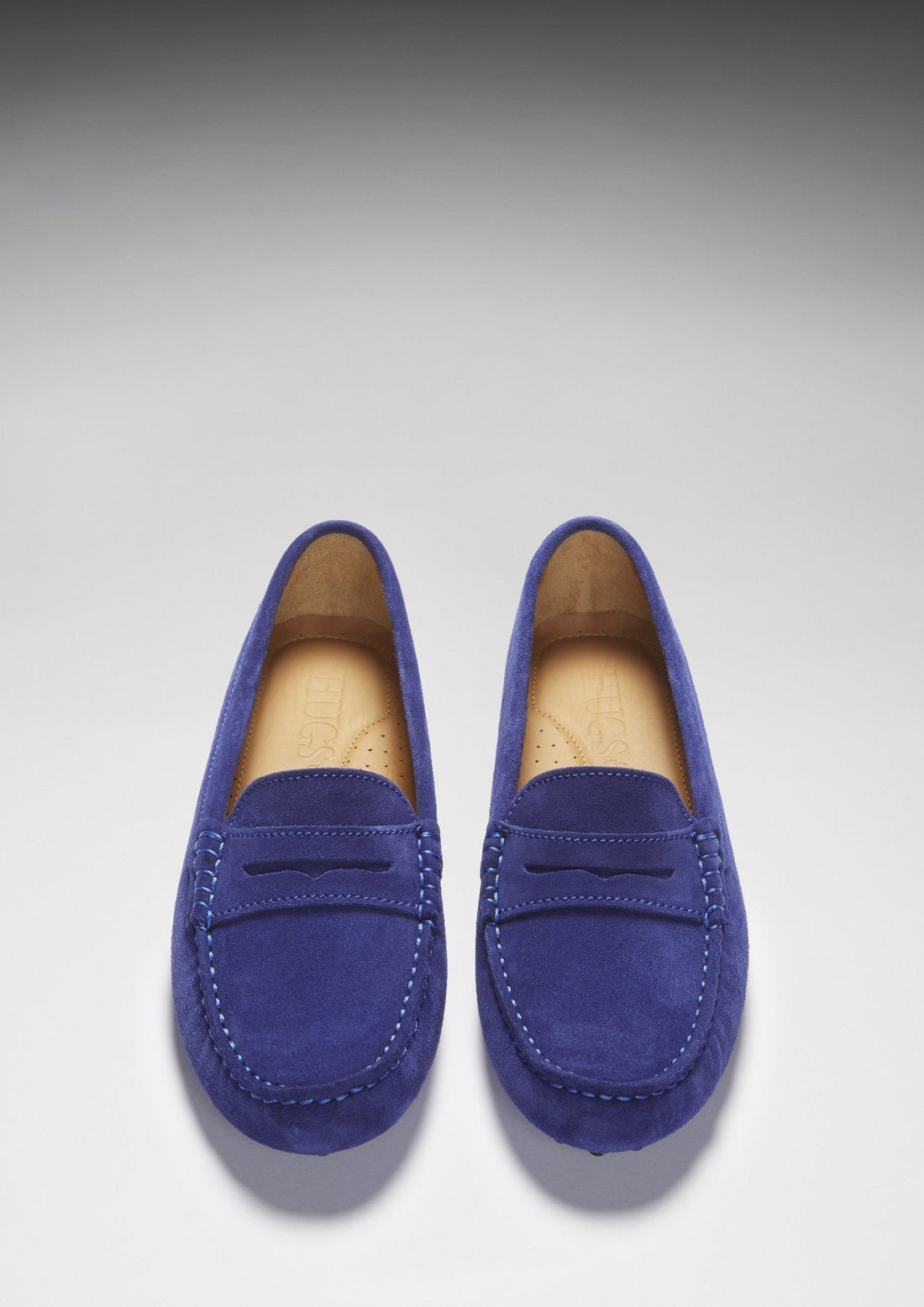 Top view of matching ink blue suede loafers with penny straps and stitched toes