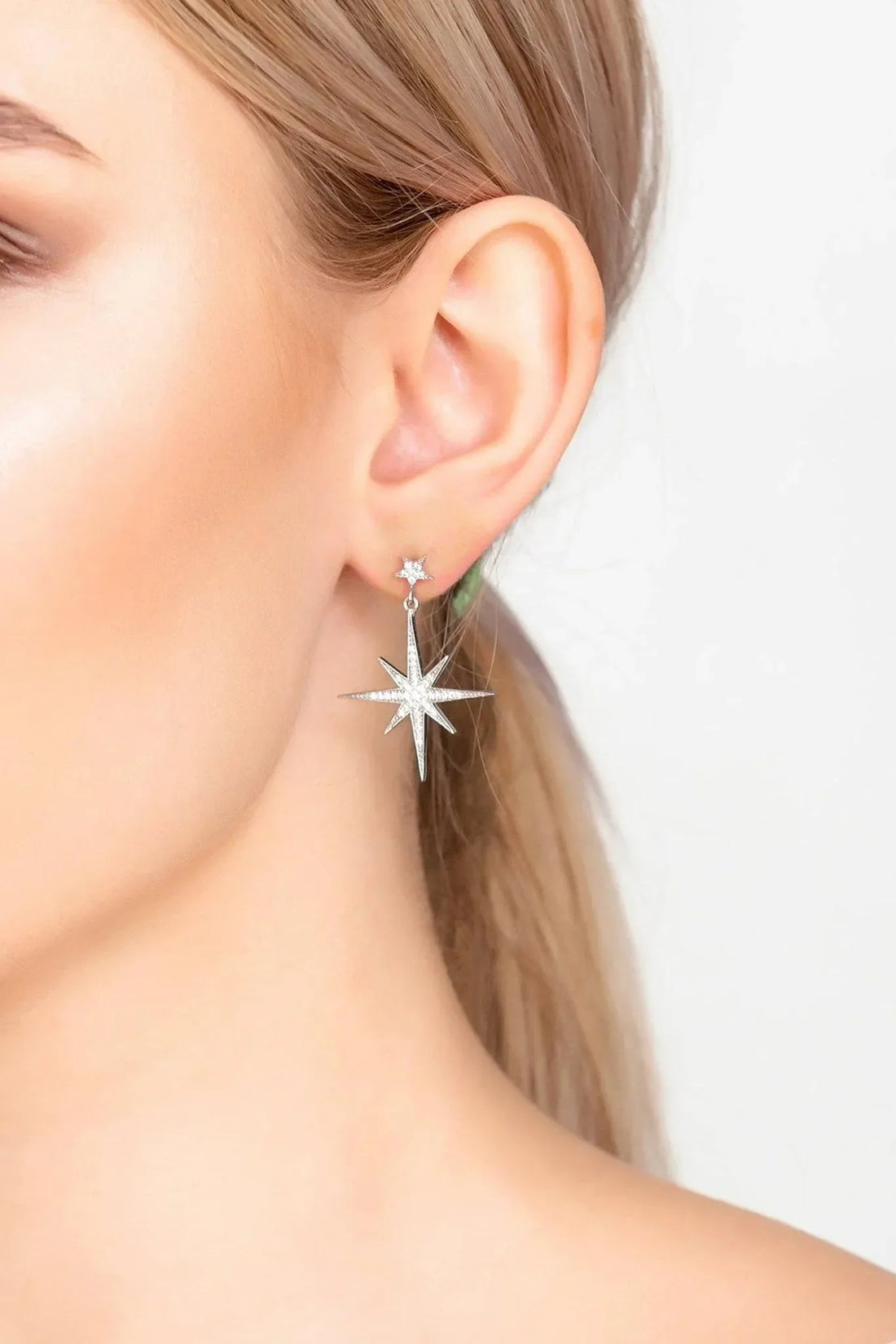 Silver starburst drop earrings with sparkly star charms and dangling detail