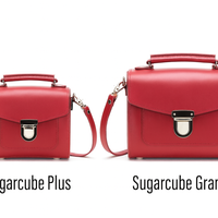 Pair of red leather square handbags with front flap and silver clasp, short top handles