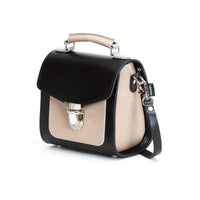 Black leather crossbody handbag with beige panel and silver top buckle, side view