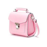 Pastel pink leather flap crossbody bag with metal clasp and adjustable shoulder strap.