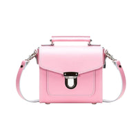 Pastel pink leather handbag with top handle, shoulder strap, and front flap clasp.