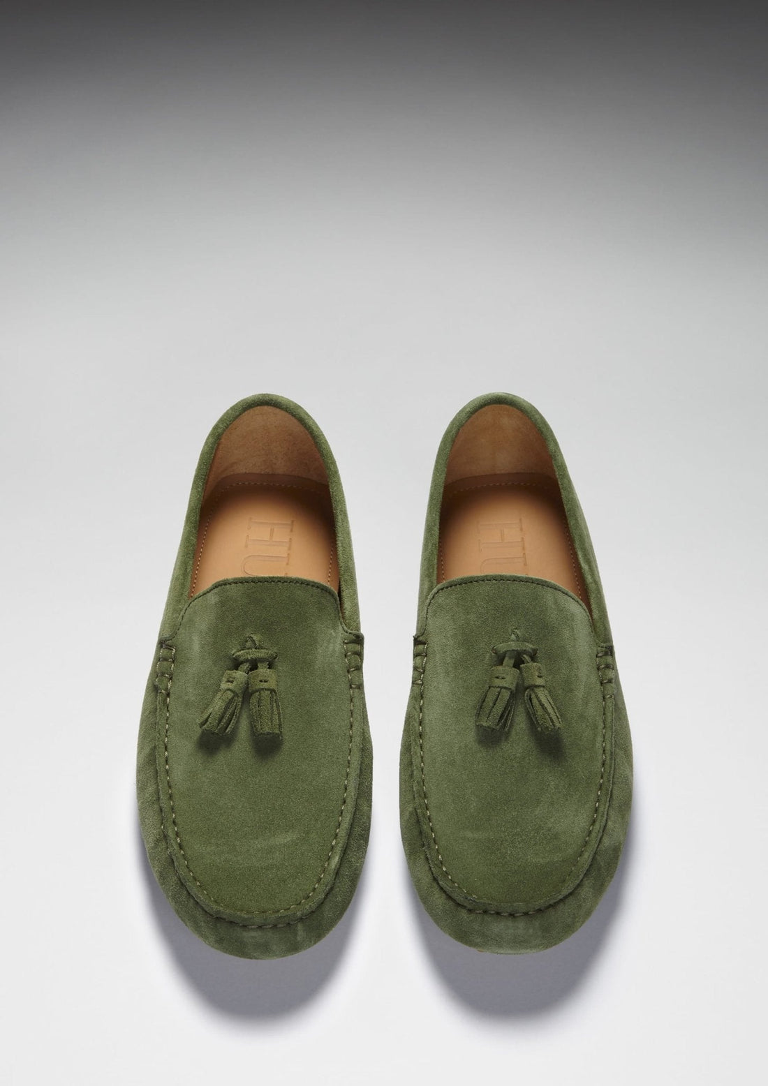 Pair of green suede tassel loafers viewed from above