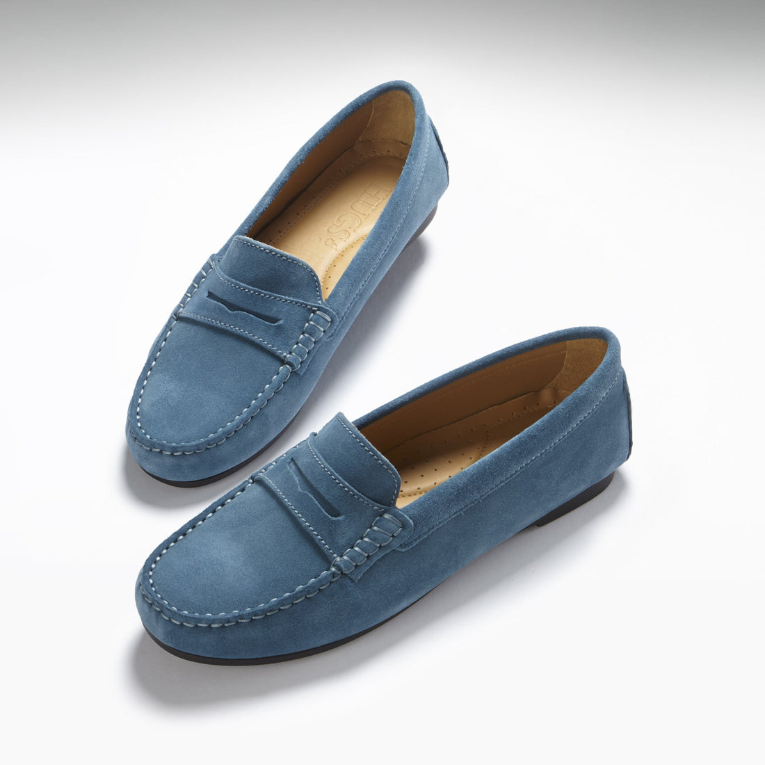 Pair of teal suede penny loafers with stitched toes and tan insoles