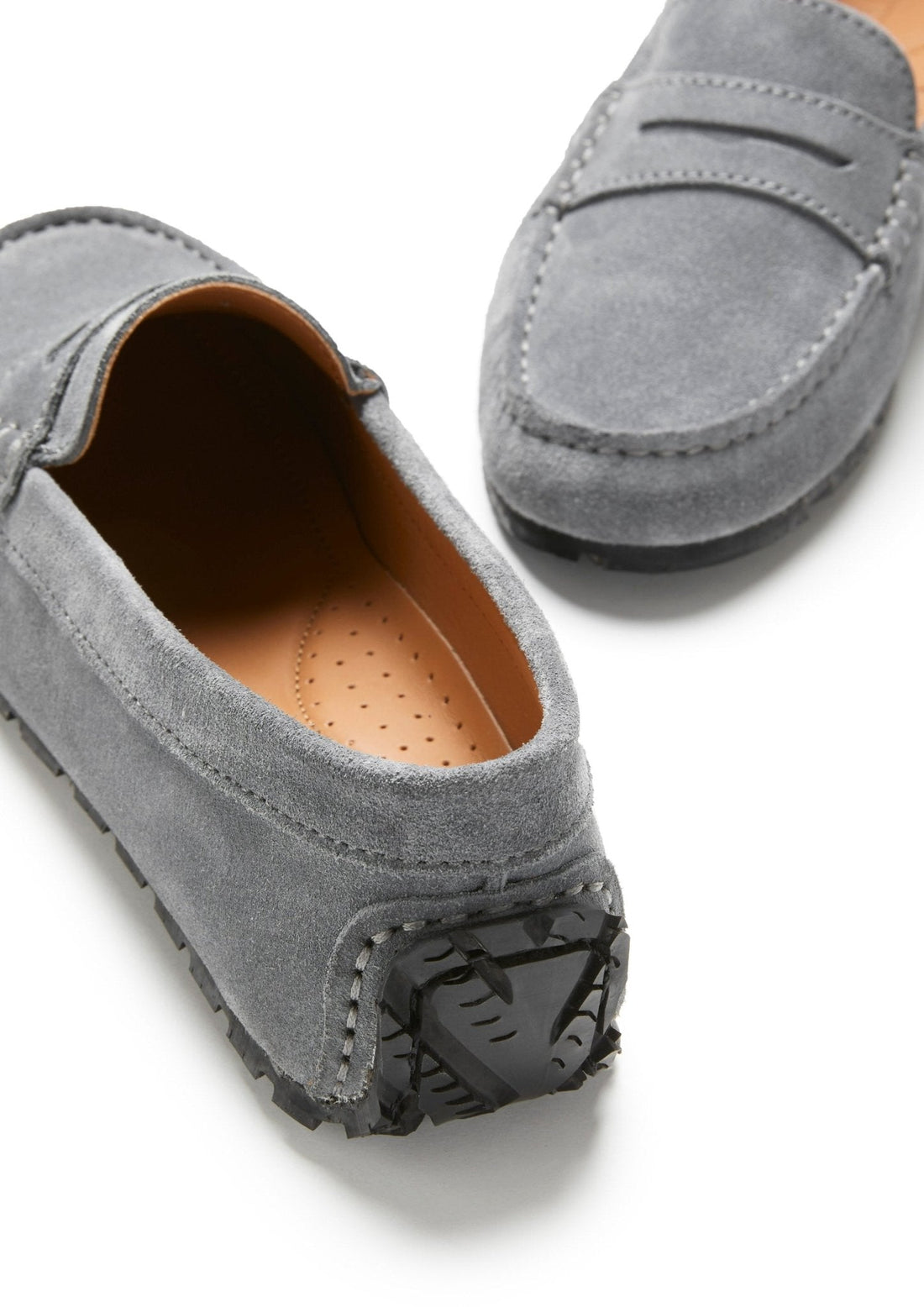 Suede loafer detail showing tan lining, stitched toe and textured heel sole