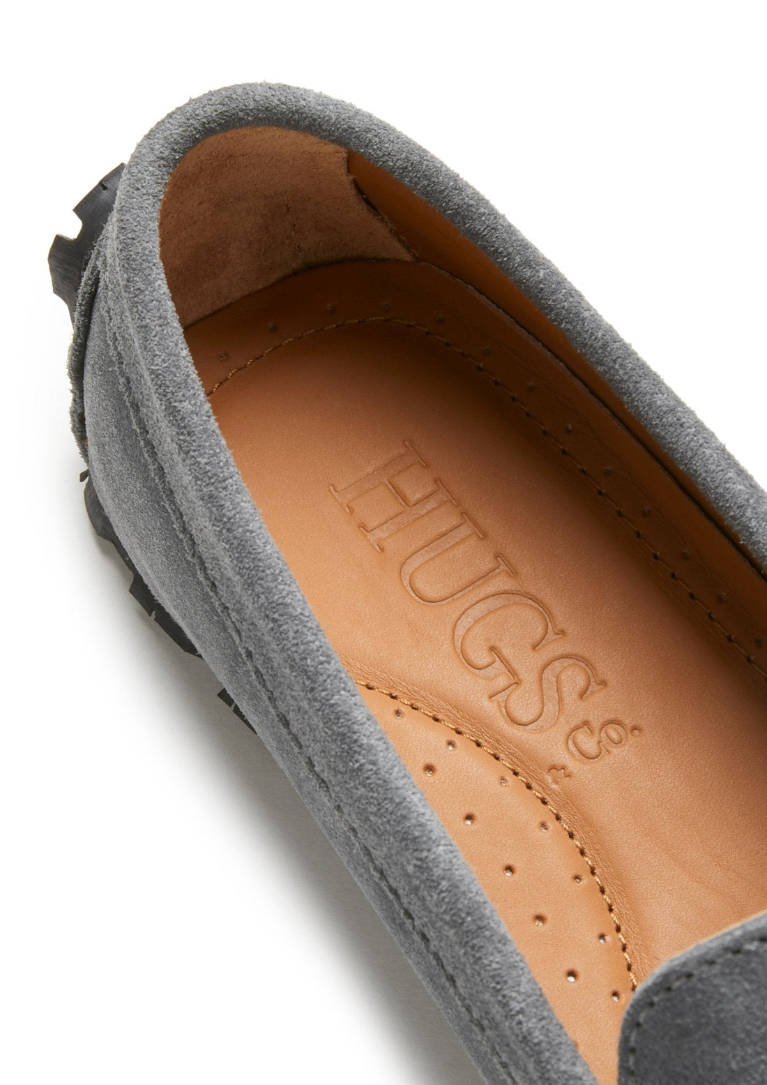 Suede loafer close-up showing tan perforated insole and HUGS & Co. branding