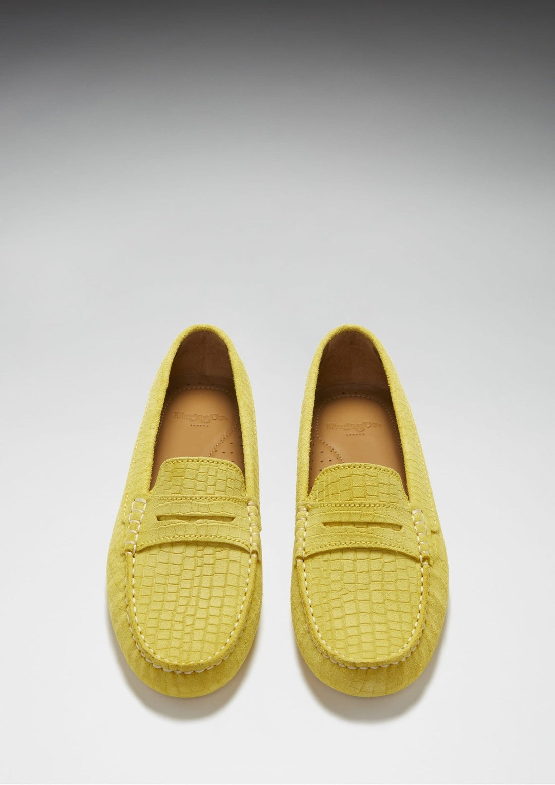 Pair of yellow embossed suede penny loafers, viewed from above