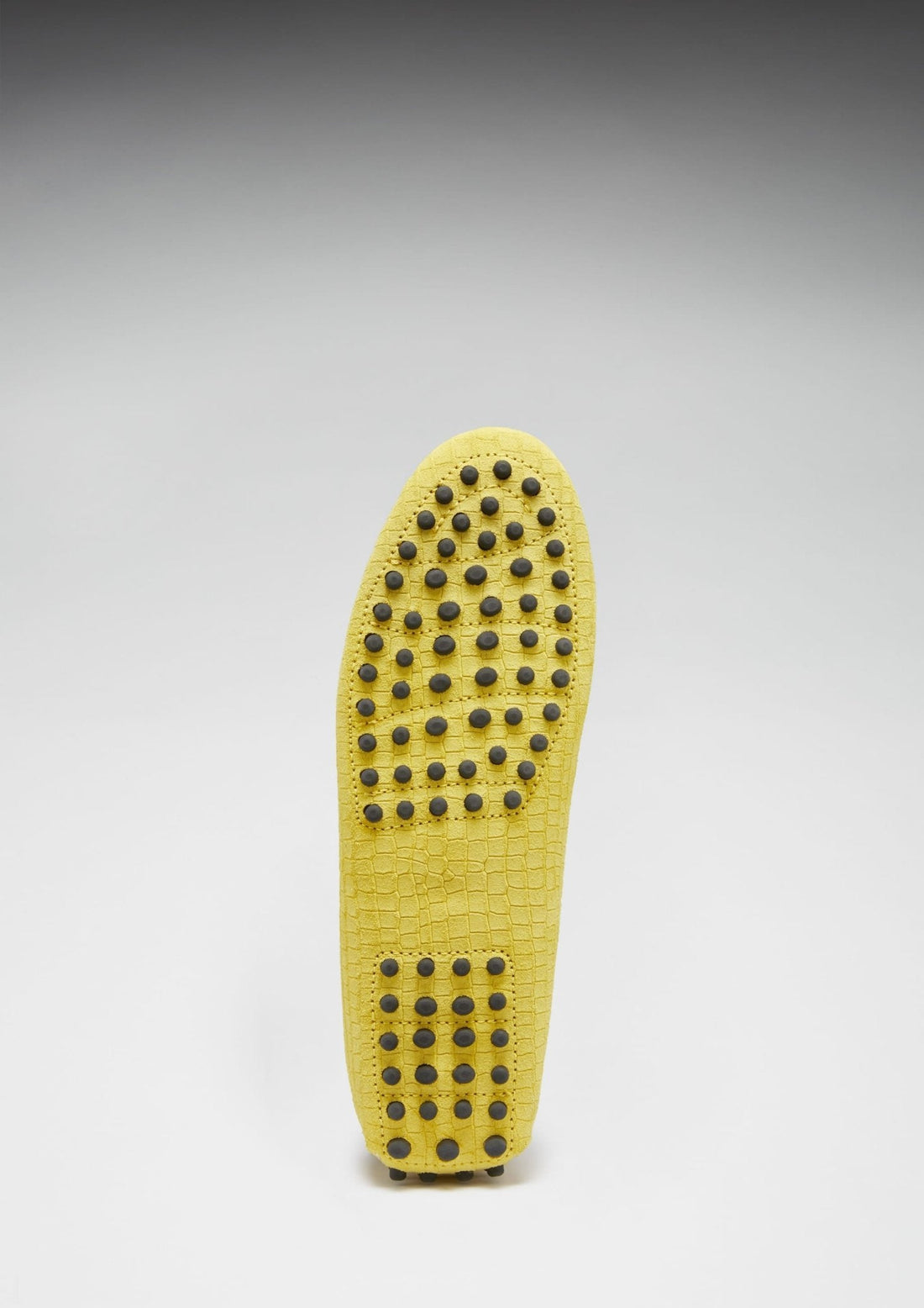 Yellow loafer sole with rows of black rubber grip dots