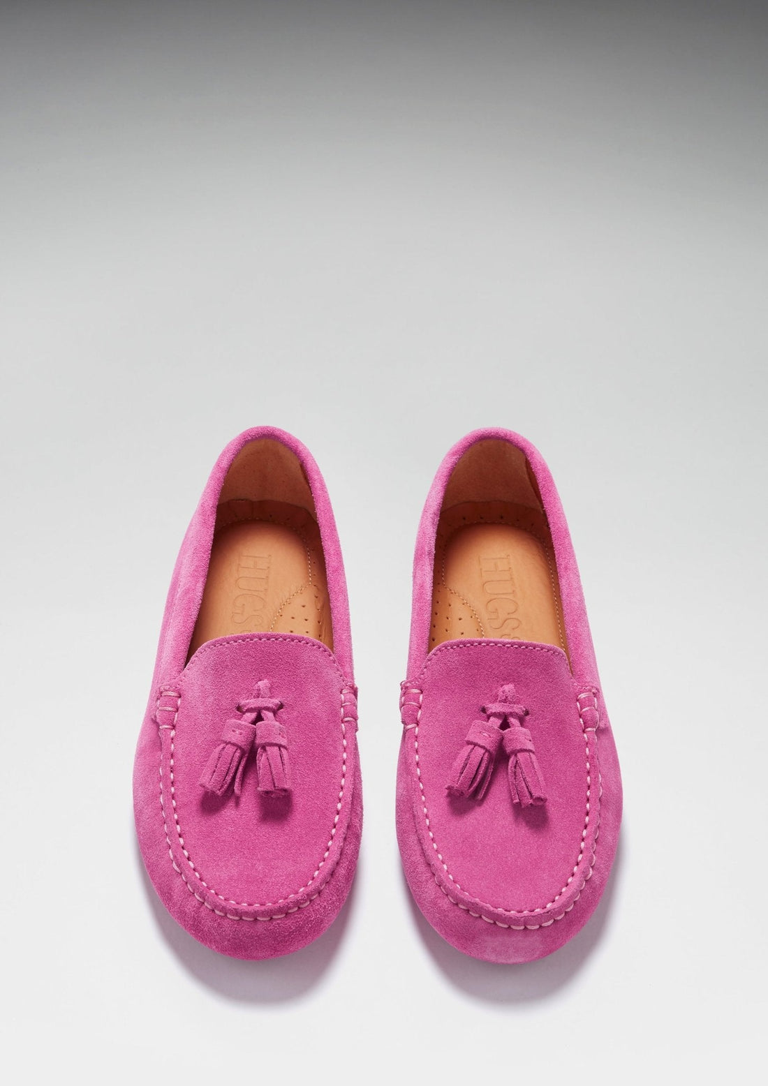 Pair of pink suede loafers with tassels, stitched apron toes, and tan insoles.