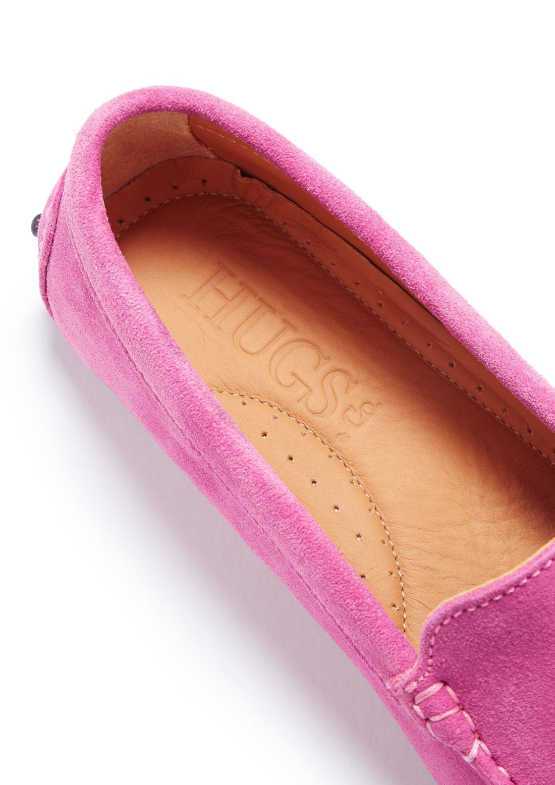 Close-up of a pink suede loafer with a tan leather insole and stitched trim.