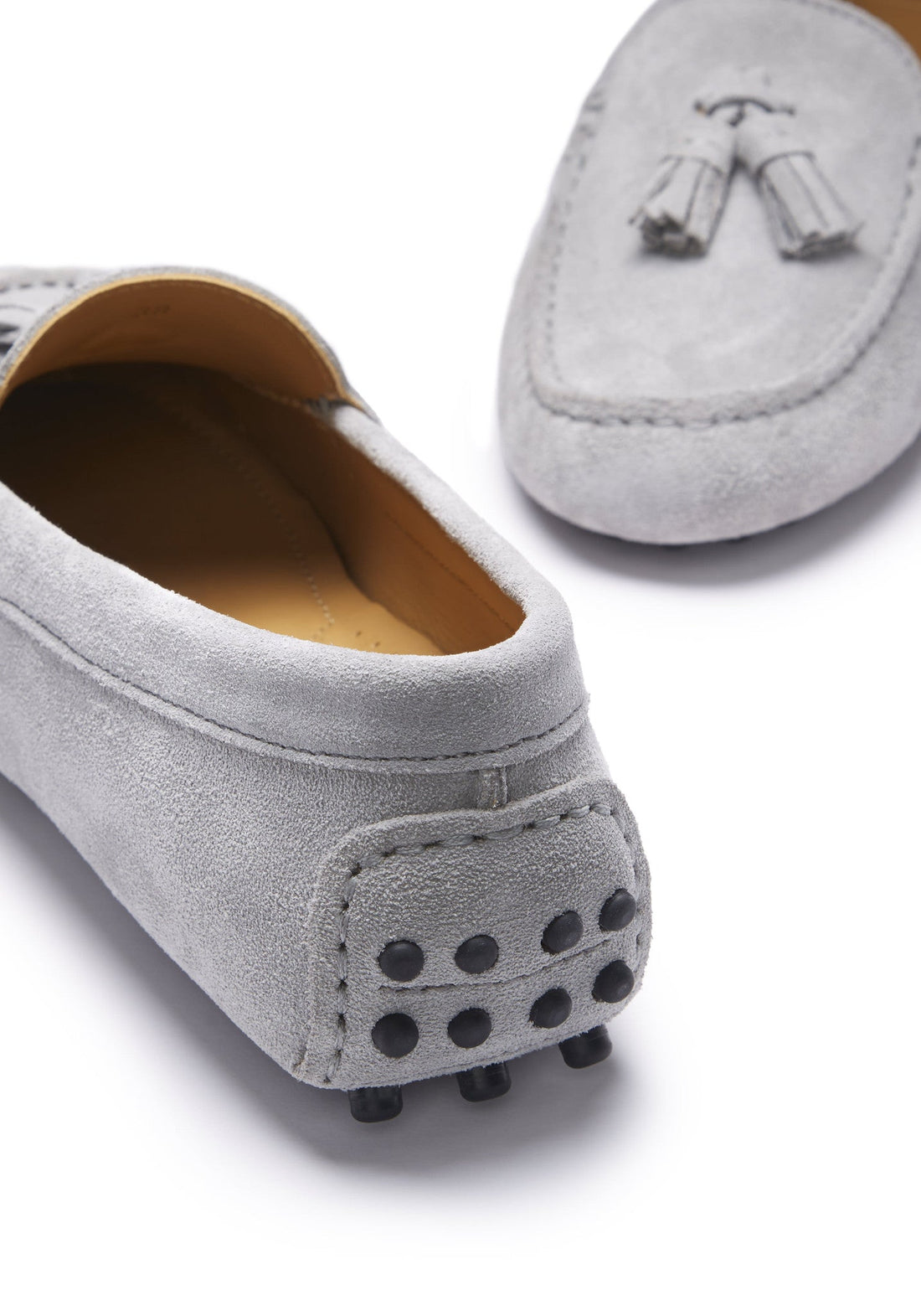 Grey suede loafer heel with rubber driving studs and tassel detail.