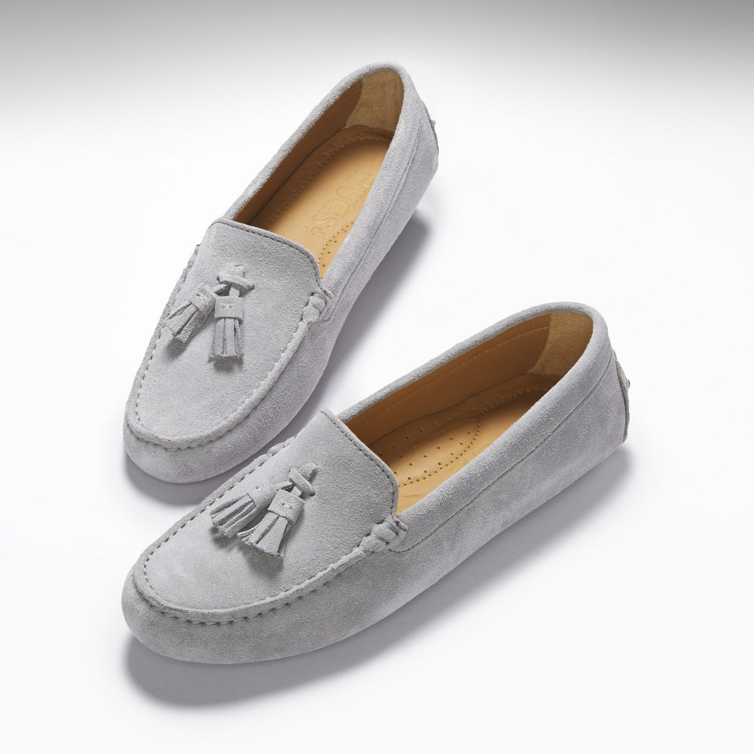 Pair of grey suede driving loafers with twin tassels and tan insoles.
