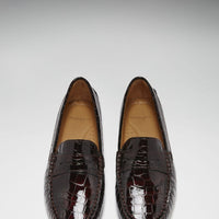 Pair of brown patent loafers viewed from above, showing penny straps and rounded toes
