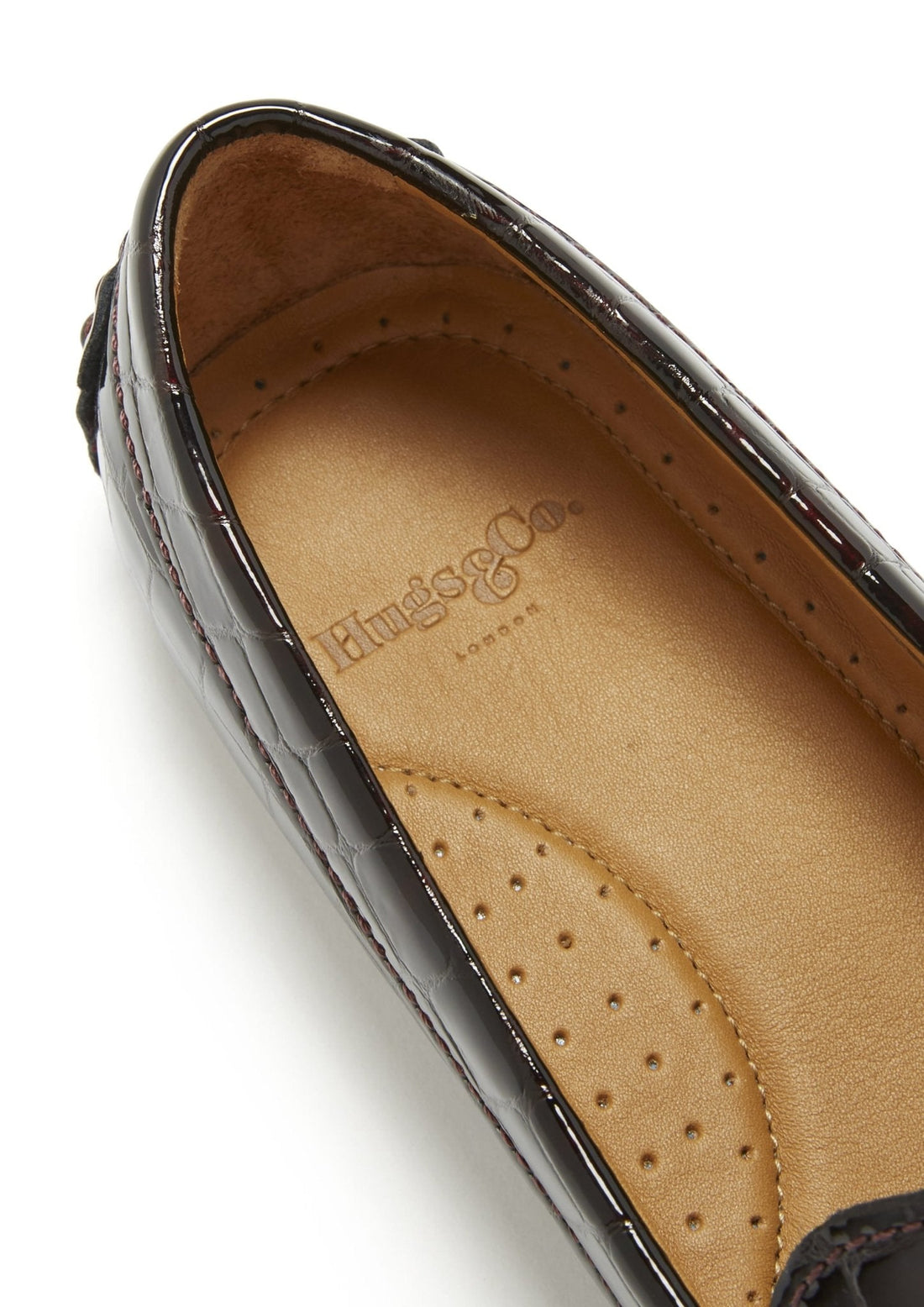 Loafer close-up showing Hugs & Co. logo and perforated tan leather insole