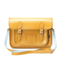 Yellow ochre leather satchel with flap top, front pocket, and adjustable crossbody strap