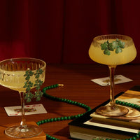 Triple drop green flower earrings on display stand, gold-tone hooks