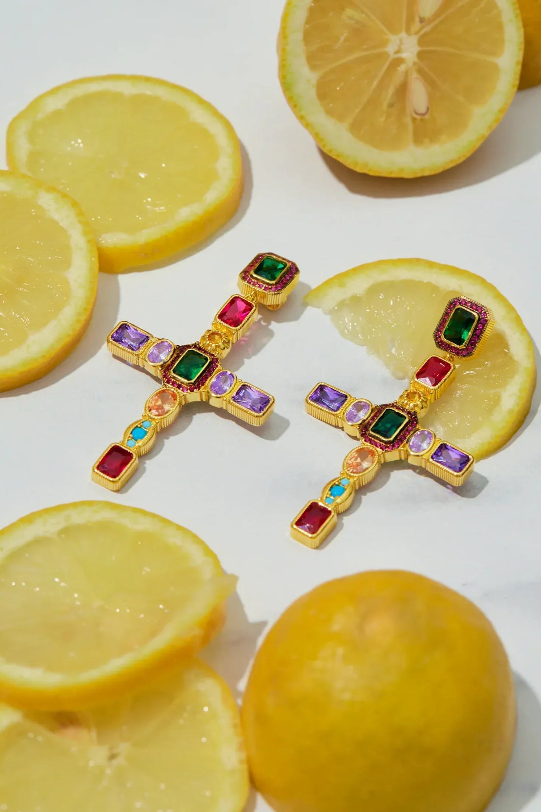 Gold cross gemstone earrings with green, red, purple, and blue accents