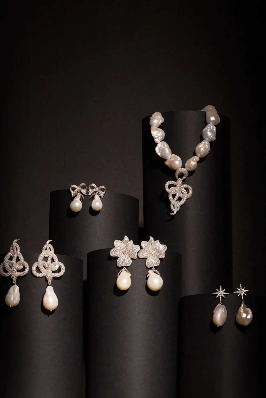 Pearl drop earrings with bow ribbon details on display, assorted styles